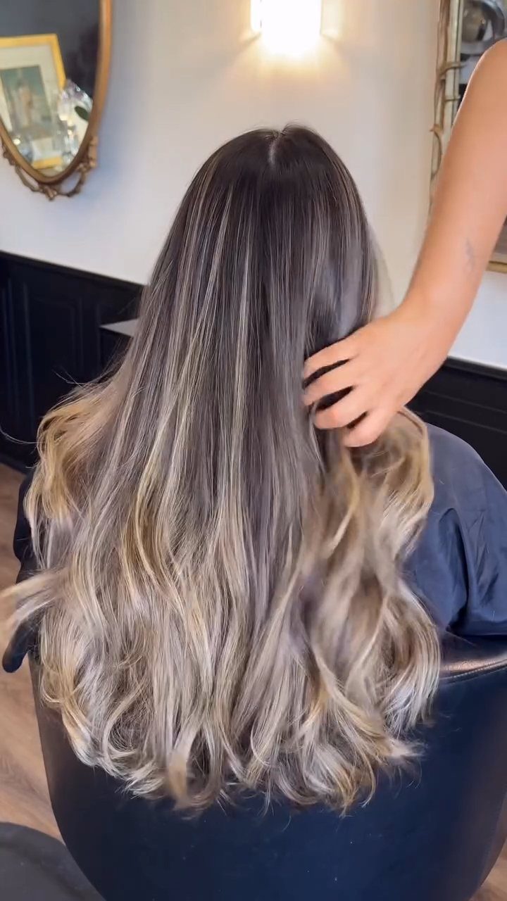 Long wavy hair with bright blonde streaks contrasting against a dark brown base
