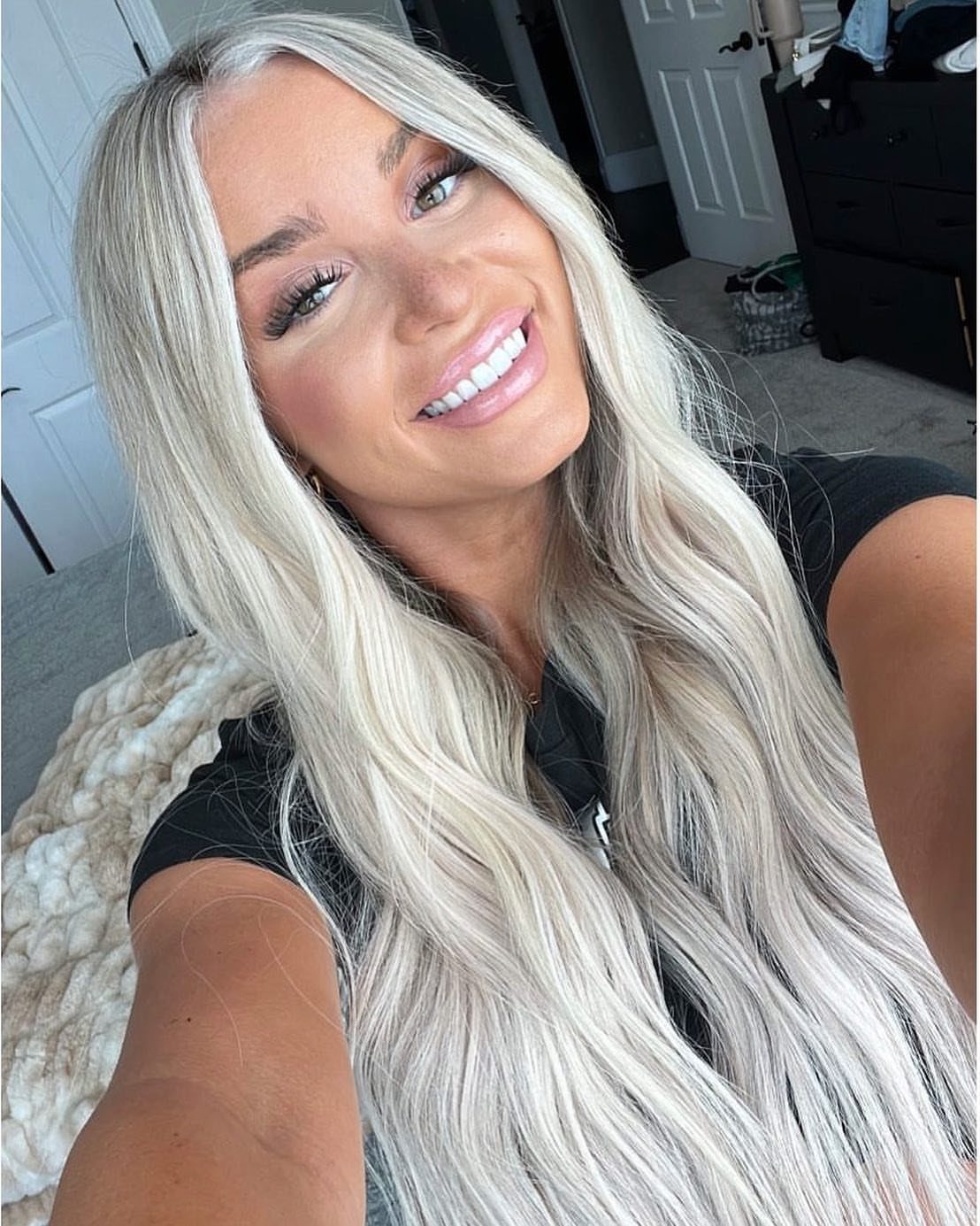 Woman with long, cool platinum ash blonde hair and darker roots