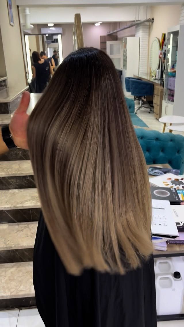 Long hair with dark roots blending into highlighted dirty-blonde lengths