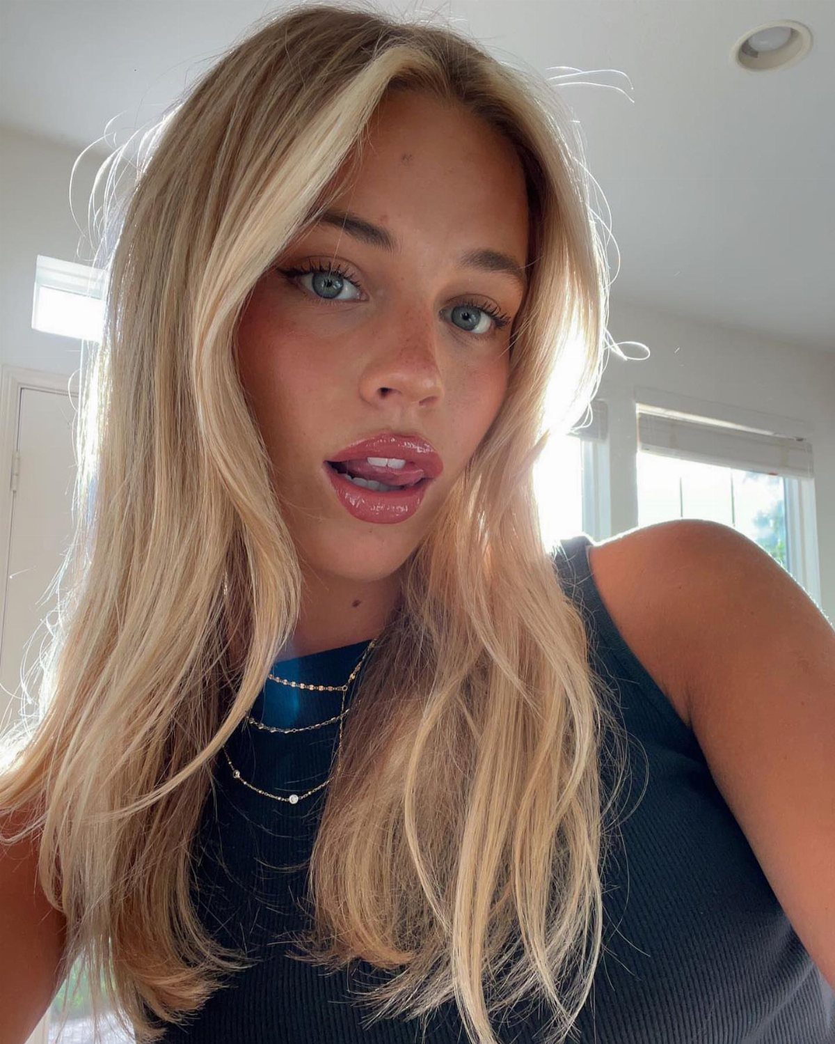 Woman with long creamy blonde waves and lighter face-framing strands