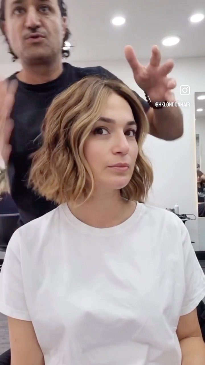 Woman displays a dimensional blonde balayage bob in a salon