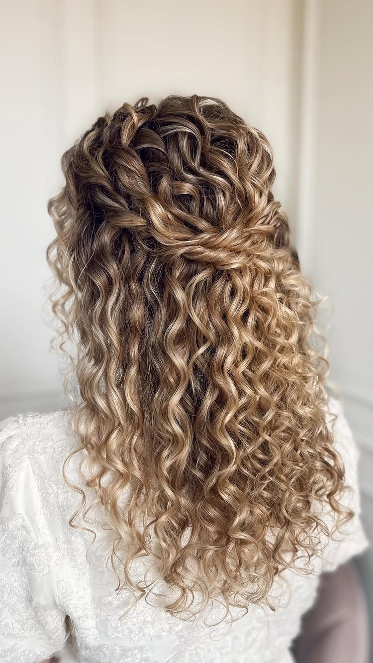 Curly brown balayage hair gathered into a partial updo with loose curls