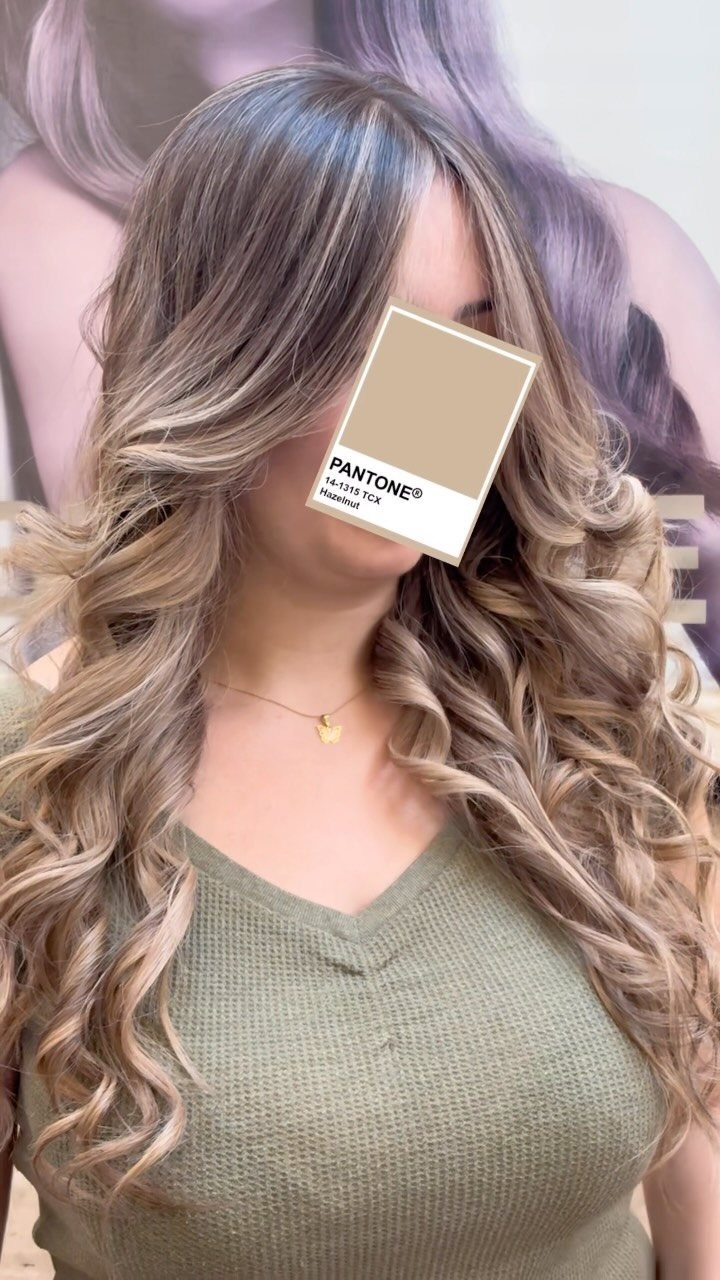 Long brown curls with broad blonde streaks and lighter face-framing strands