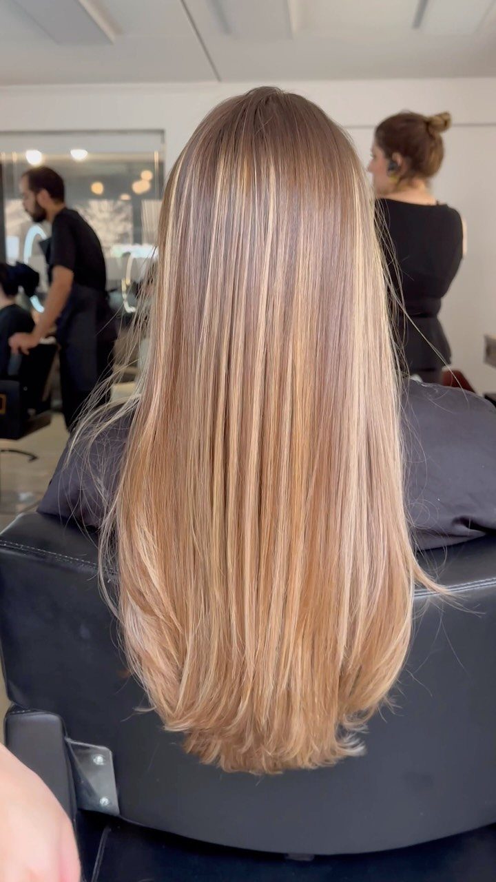 Long light brown hair with fine blonde highlights in a salon
