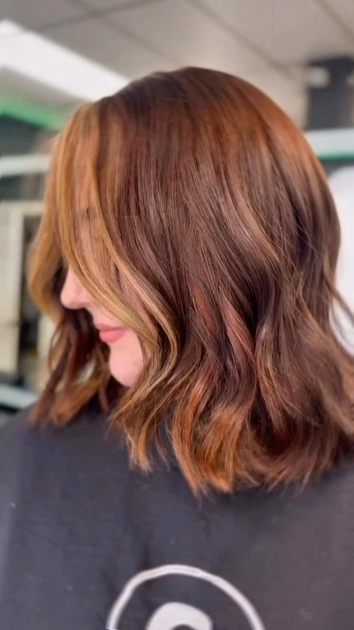 Shoulder-length brown hair with caramel face-framing highlights in a salon