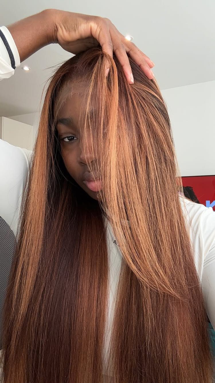 Long straight brown hair with prominent copper-red highlights