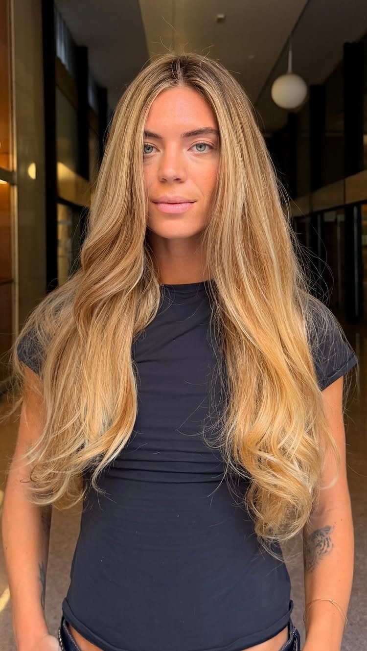 Woman showing long wavy blonde hair with cool-toned highlights