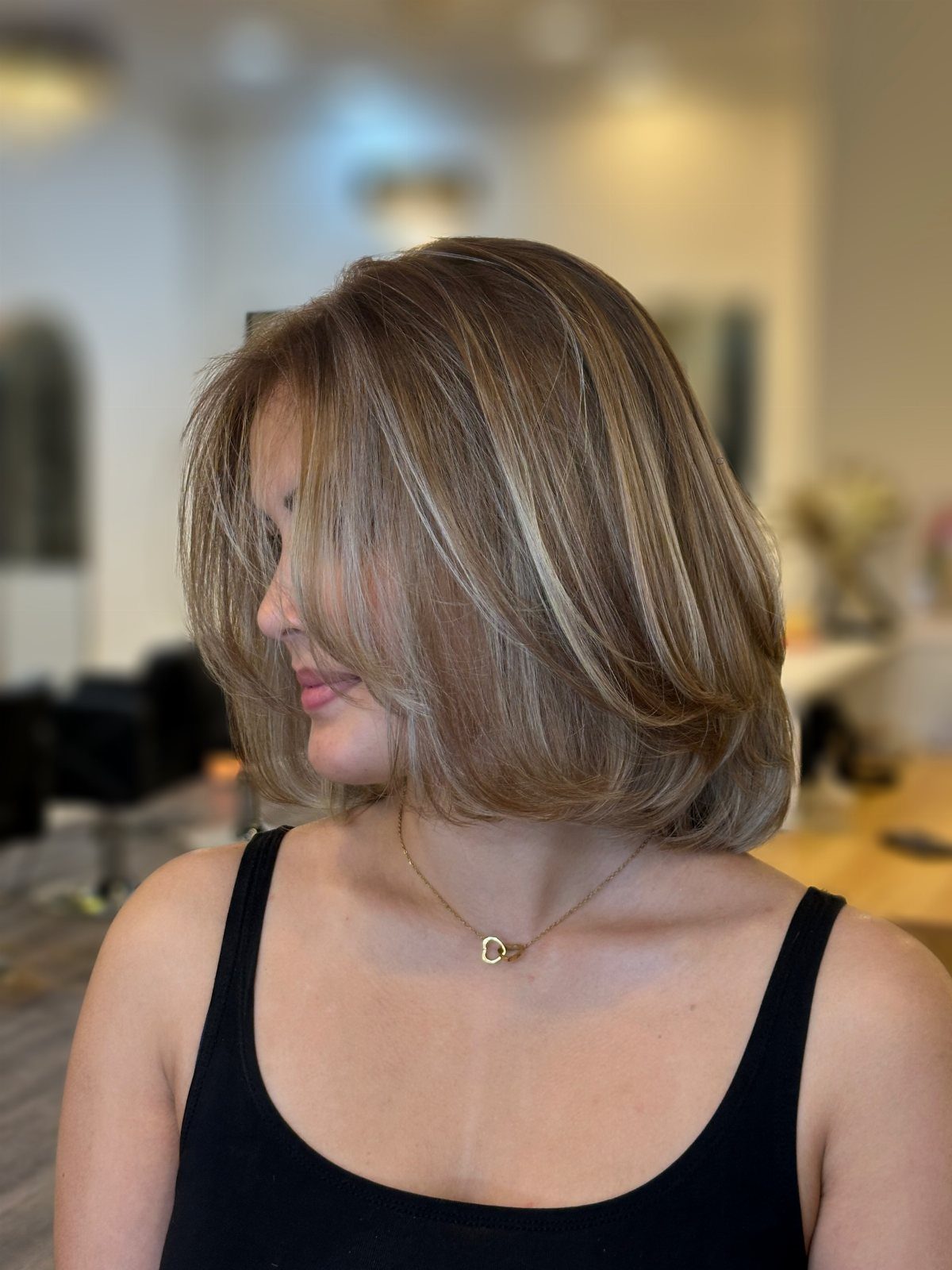 Woman showing a layered brown-blonde bob with blended highlights