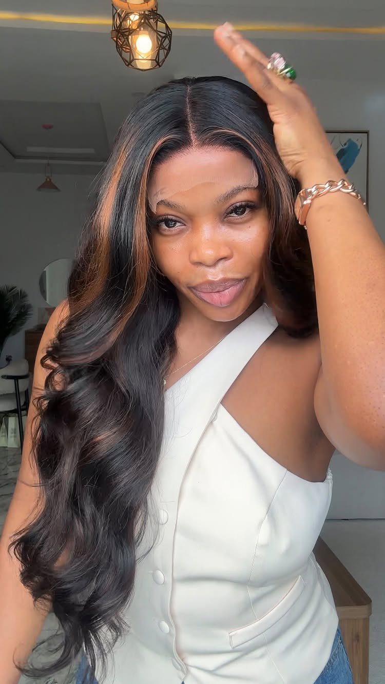 Woman displaying long black-brown hair with subtle warm highlights and loose waves