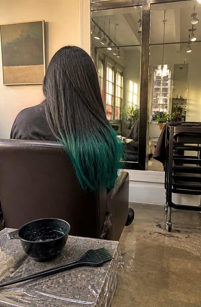 Black hair ending in vivid peacock green with a sharp color line