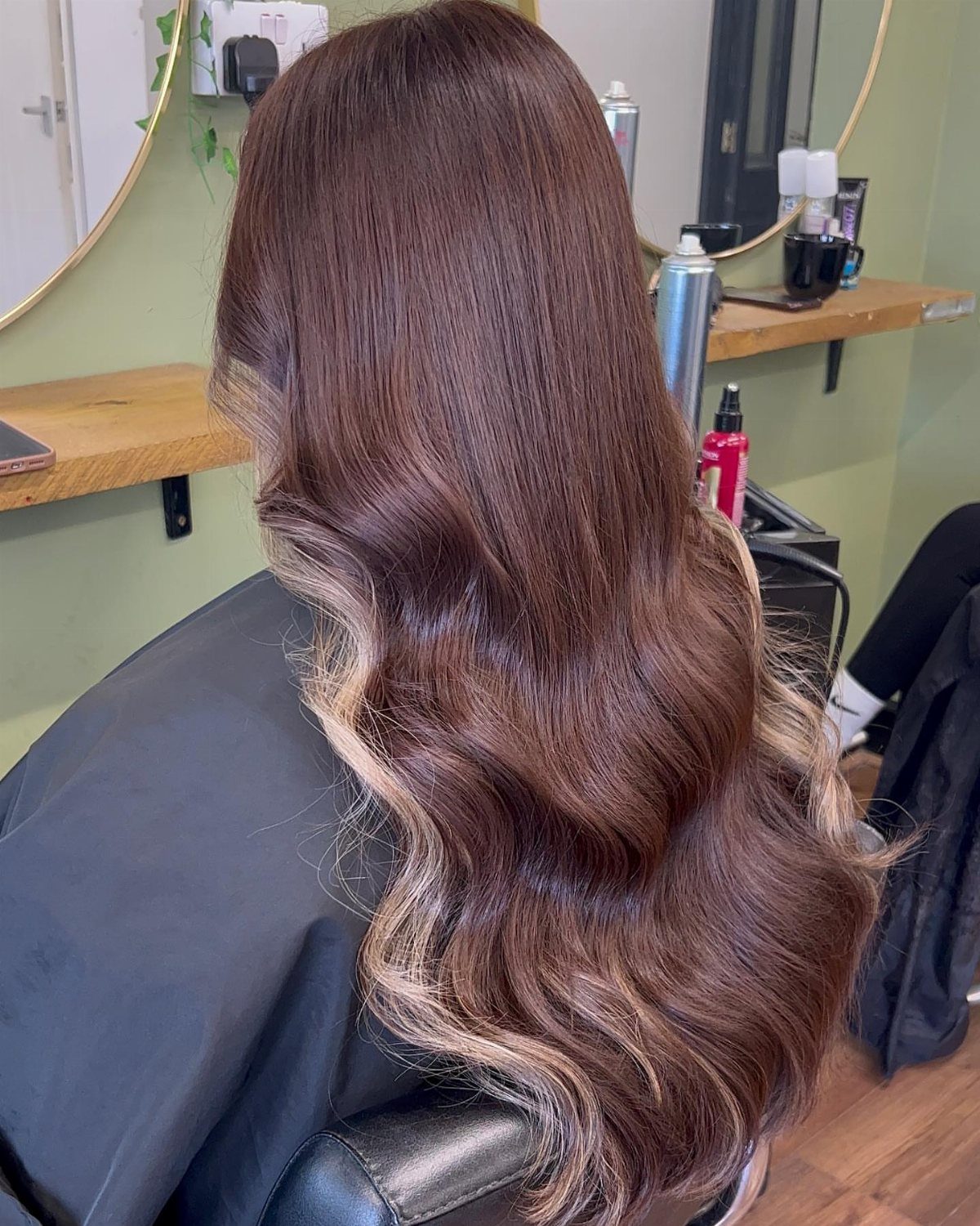 Long light-brown waves with pale blonde highlights through the lengths and curled ends