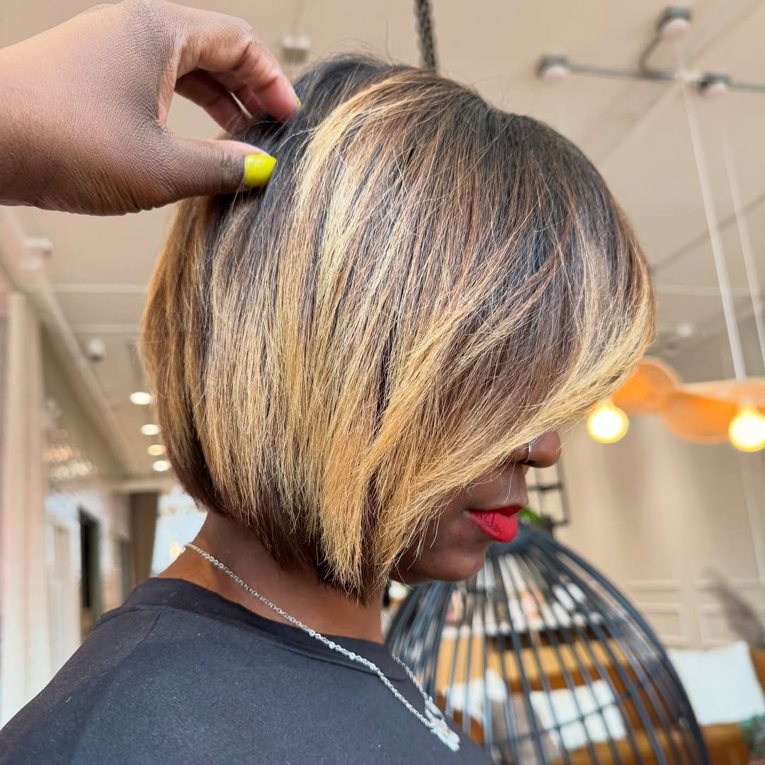 Short angled bob with blonde and caramel highlights being parted in a salon