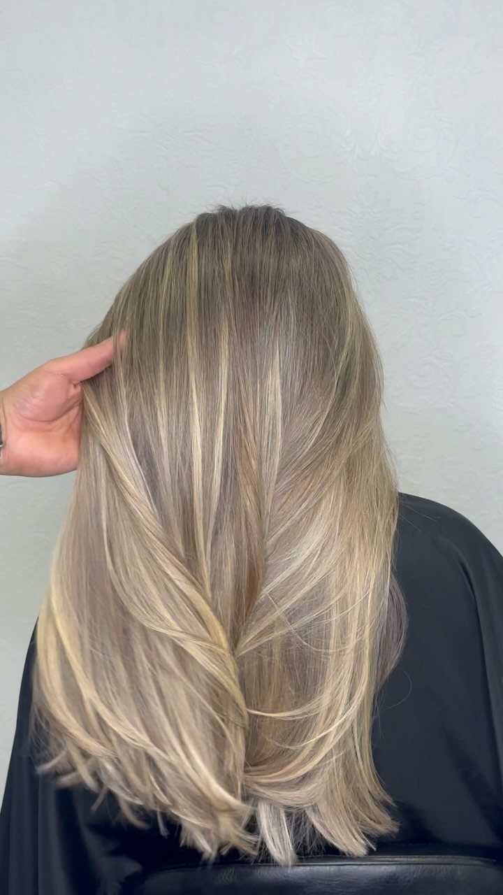 Blonde hair shows fine, subtle highlights through layered shoulder-length strands