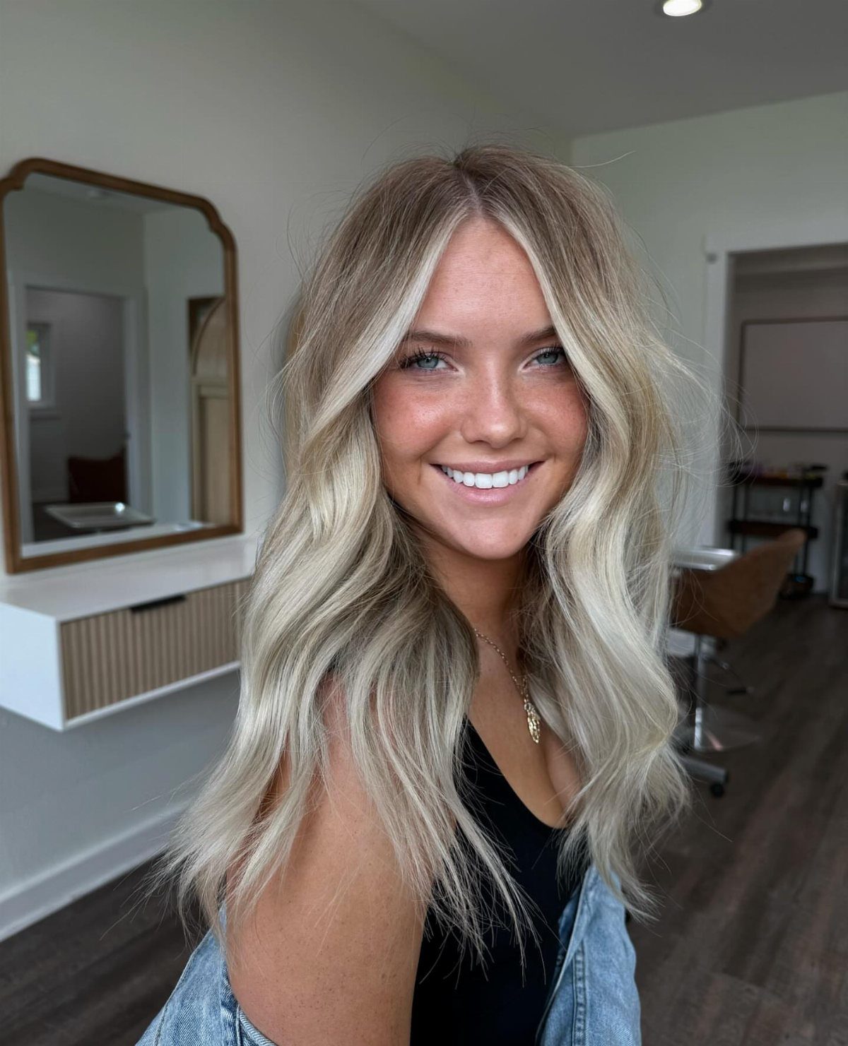 Woman with long wavy ash-blonde hair and light toasted highlights