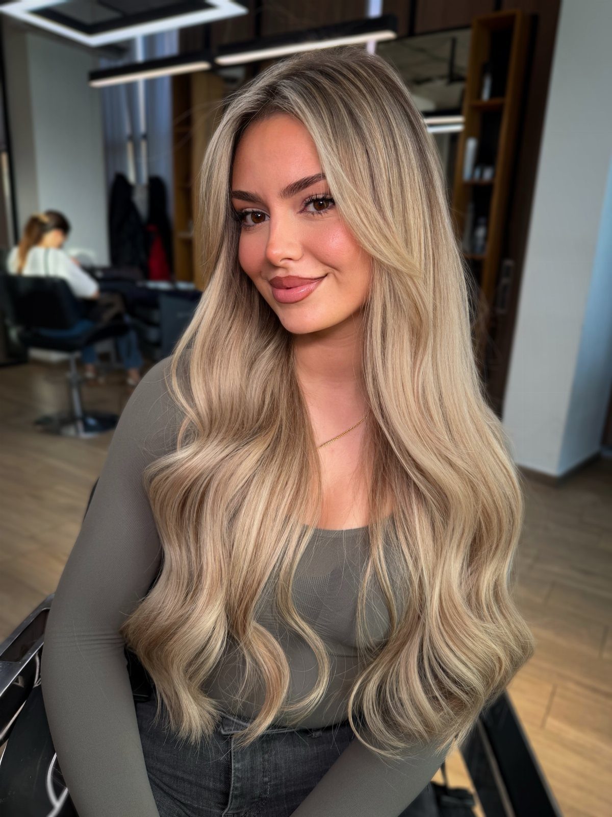 Woman with long, wavy blonde hair and cool pale highlights in a salon