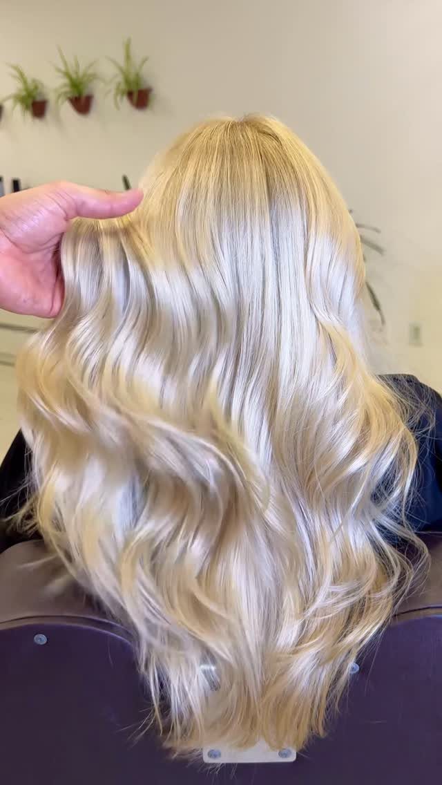 Long platinum blonde waves with warm golden tones shown from behind