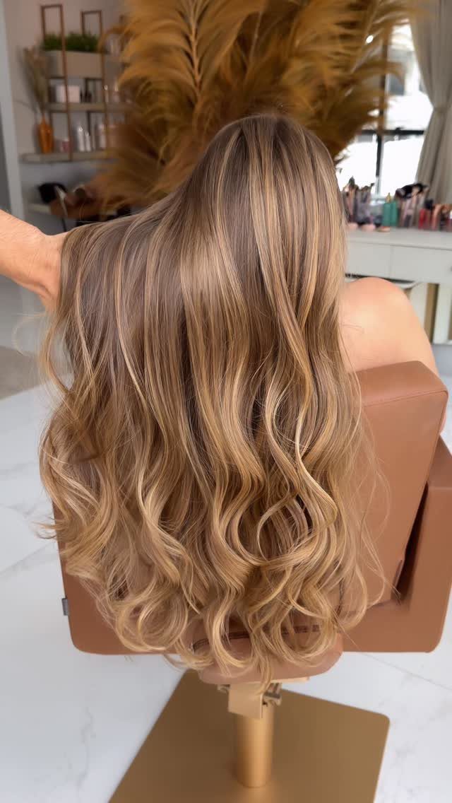 Long wavy blonde hair with warm golden highlights displayed on a mannequin