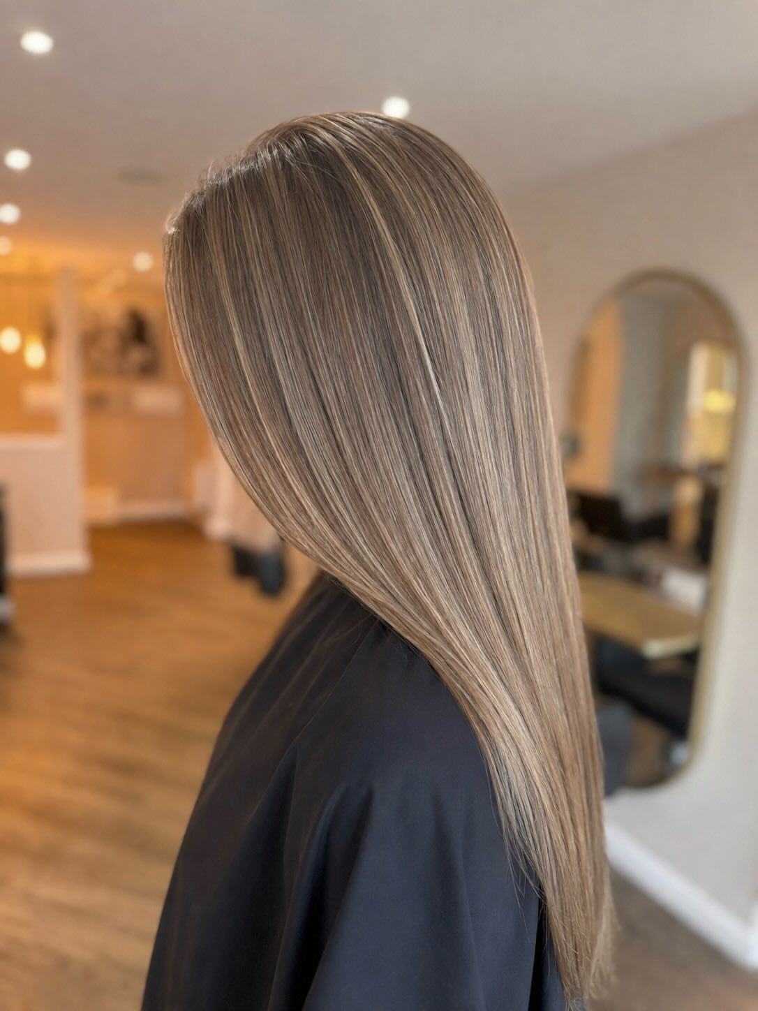 Long straight blonde hair with subtle tonal highlights in a hair salon