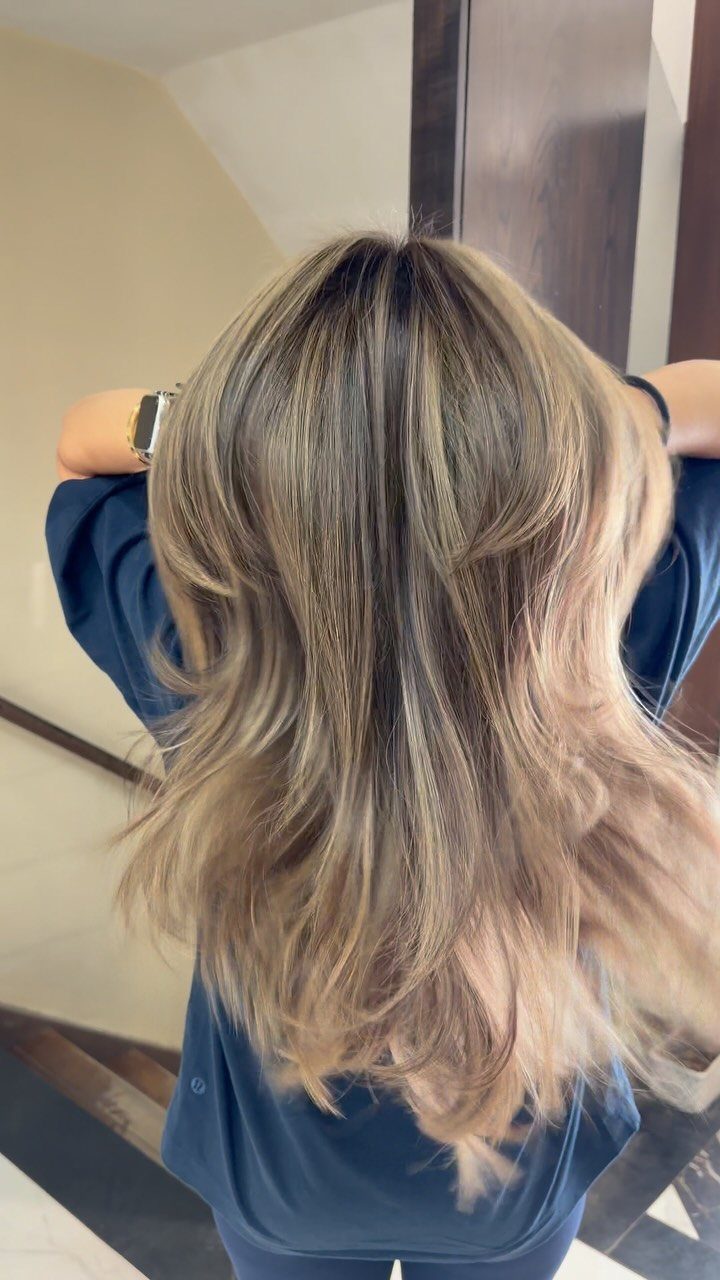 Layered ash-blonde hair with subtle sandy, sunlit highlights