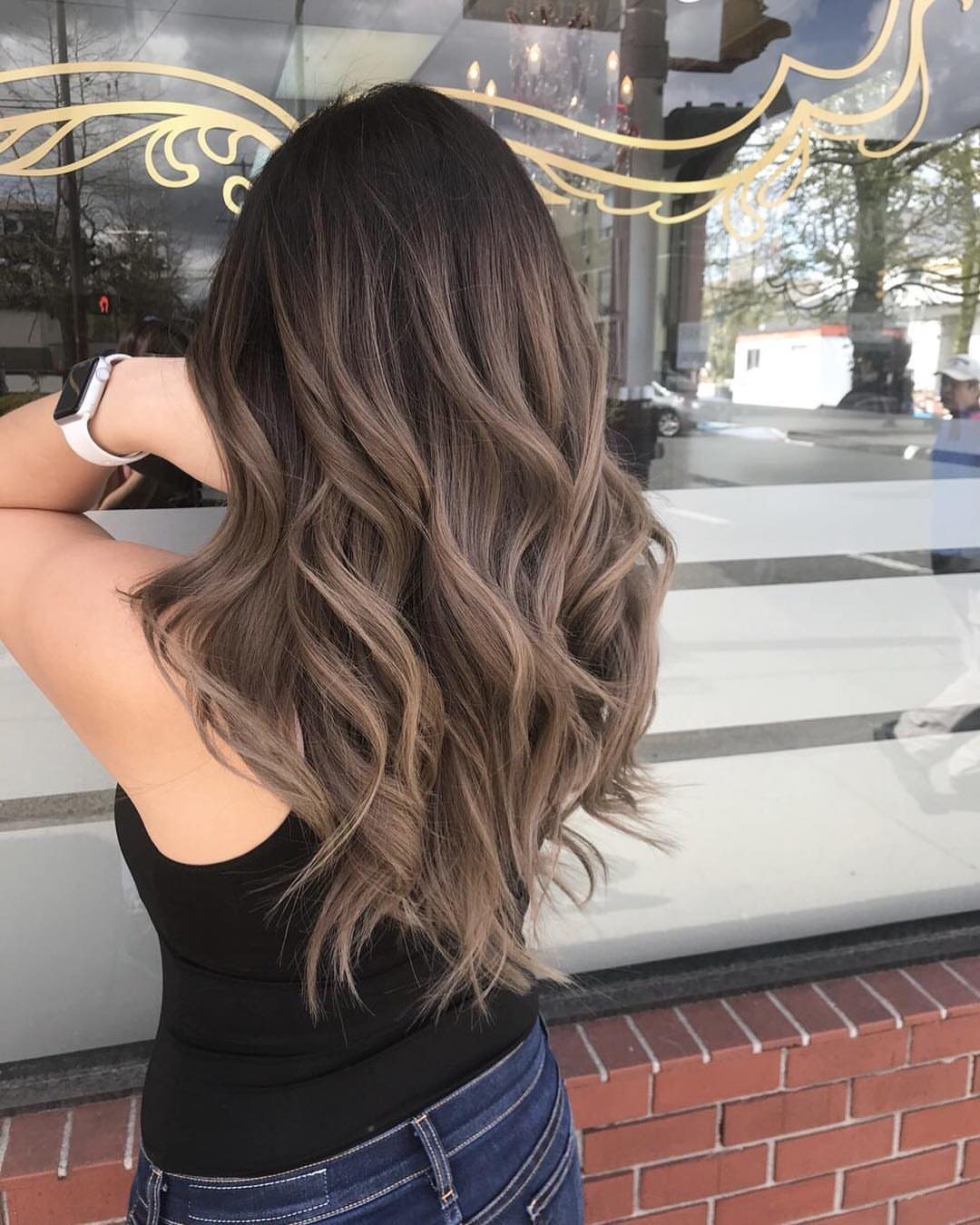 Wavy brown hair with cool ash highlights shown from behind