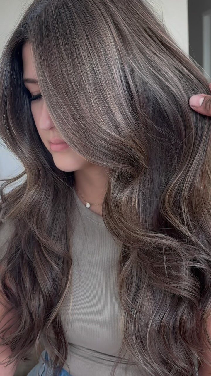 Long wavy brown hair with subtle cool ash and taupe highlights