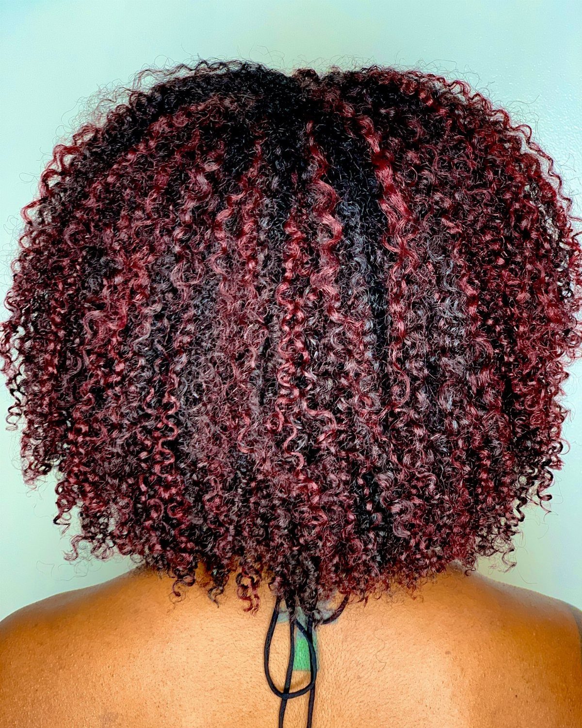 Tight black finger coils with red highlights covering the back of the head