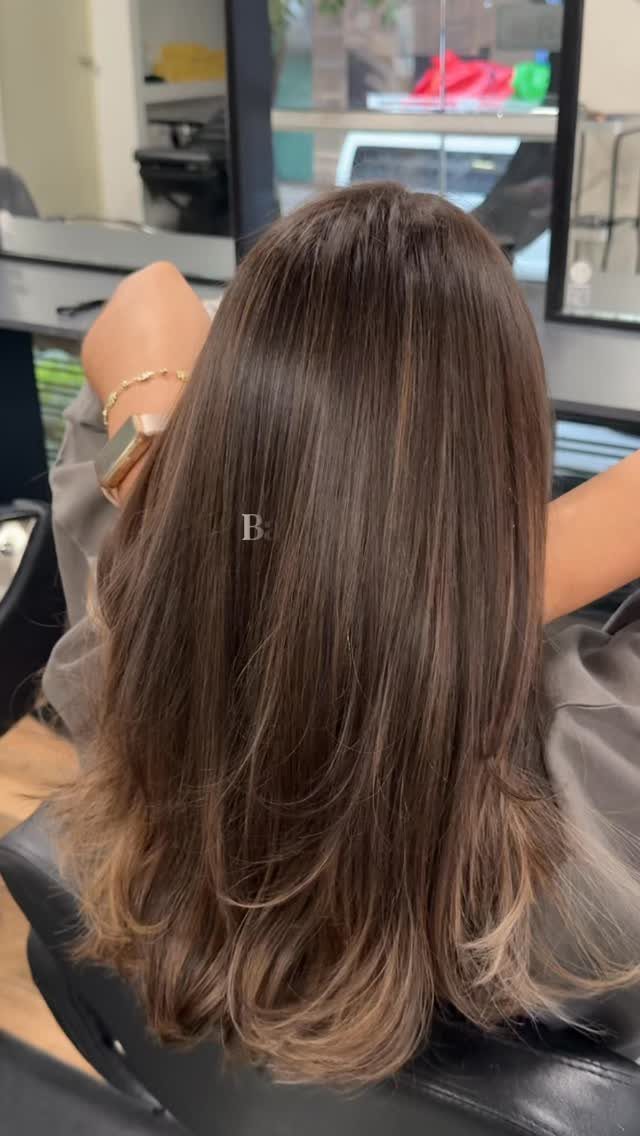 Long brunette hair with fine, subtle lighter strands and curled ends