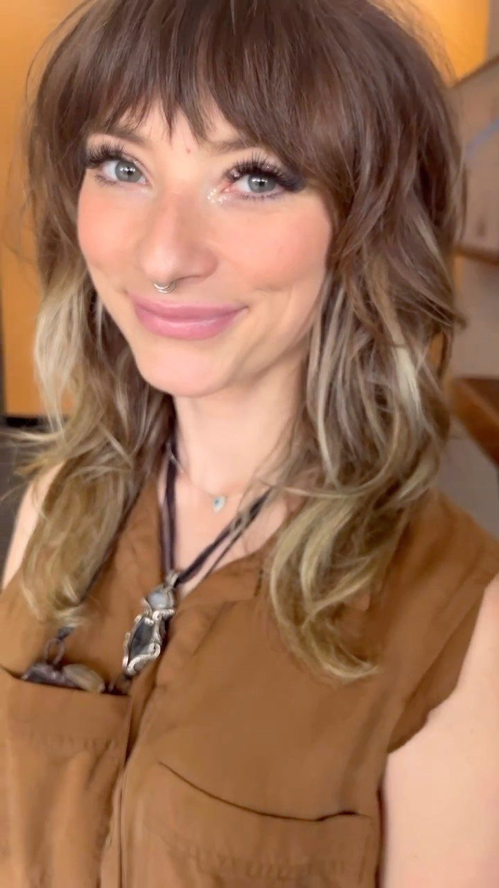 Woman with brunette balayage and soft lighter highlights through the lengths