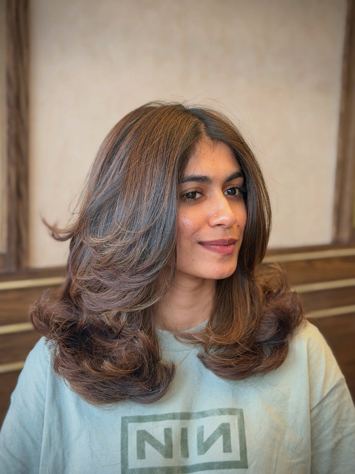 Woman with layered brunette hair and subtle warm chestnut highlights