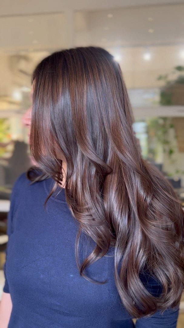 Long brunette hair with subtle caramel tones styled in loose waves