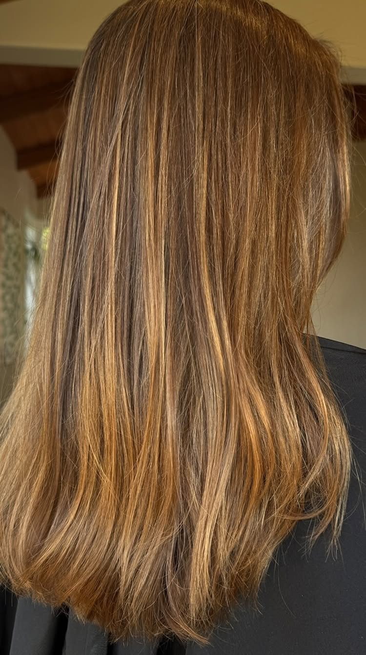 Wavy brunette hair with warm copper highlights and lighter strands