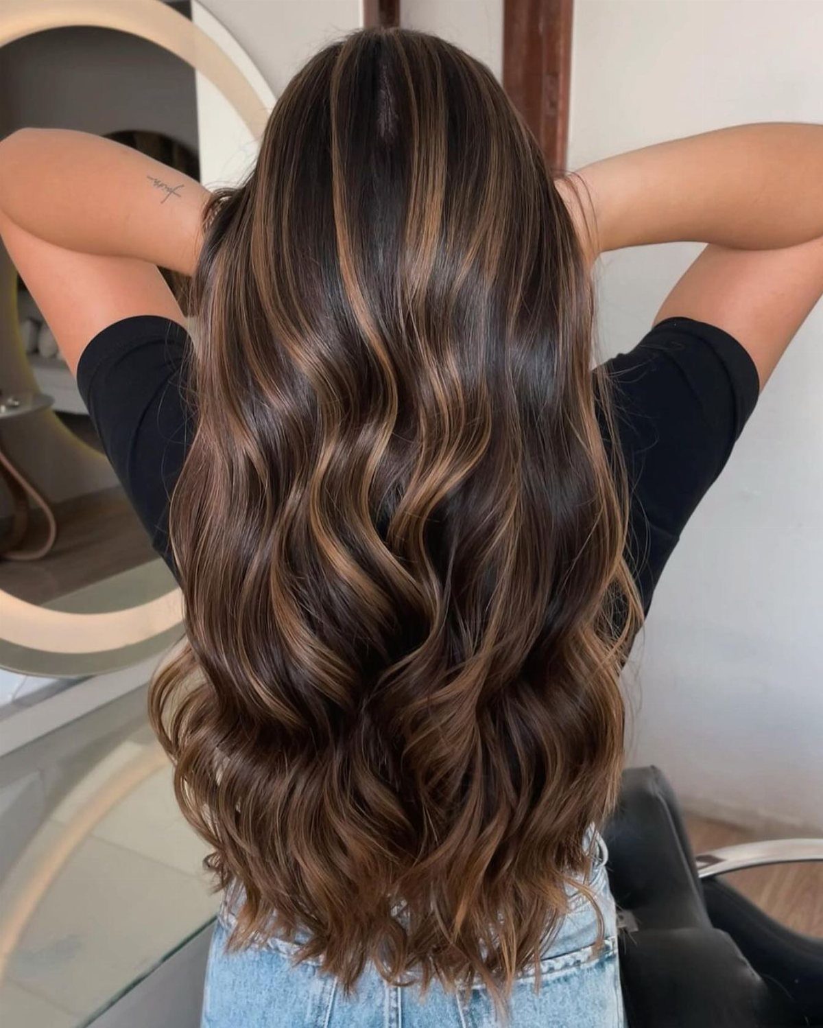 Long wavy brown hair with subtle honey highlights framing the crown