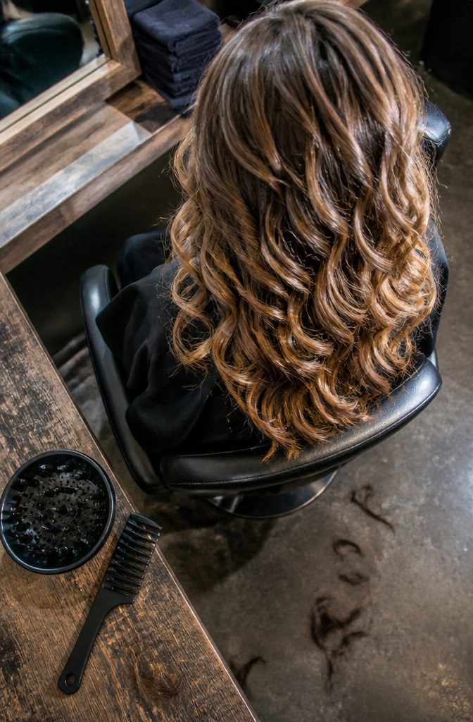 Brunette curls with honey blonde highlights and a soft dark root