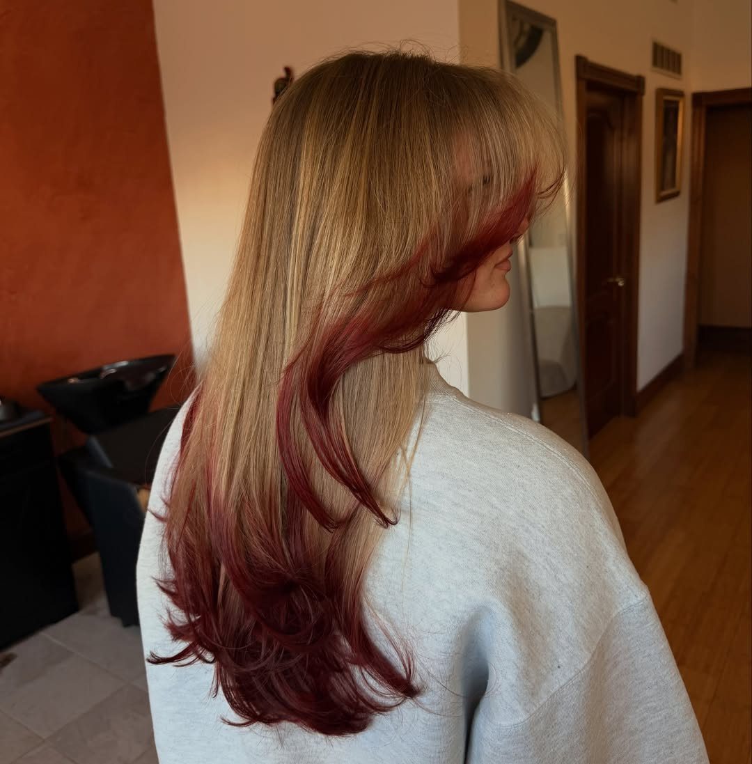 Long blonde hair with red lowlights flowing through the lower lengths