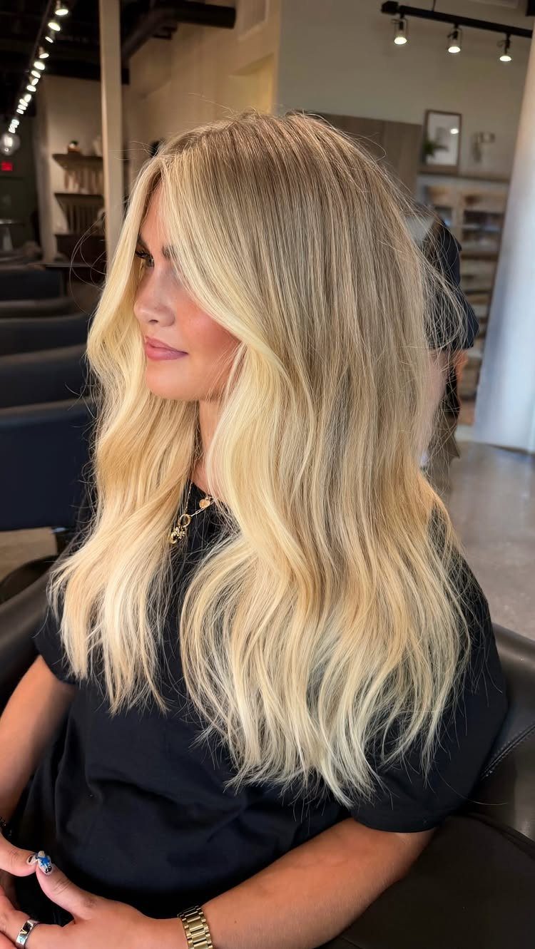 Woman with long wavy blonde hair showing pale blonde sections and darker lowlights