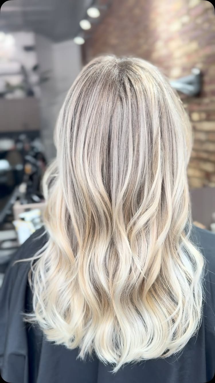 Long icy blonde waves show pale tones and darker lowlight strands