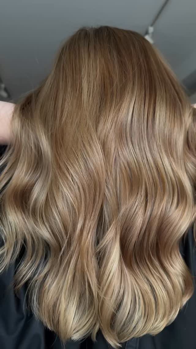 Long wavy blonde hair with darker lowlights shown from behind