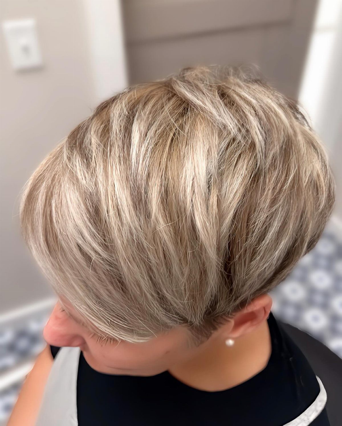 Short blonde pixie with darker lowlights in layered hair