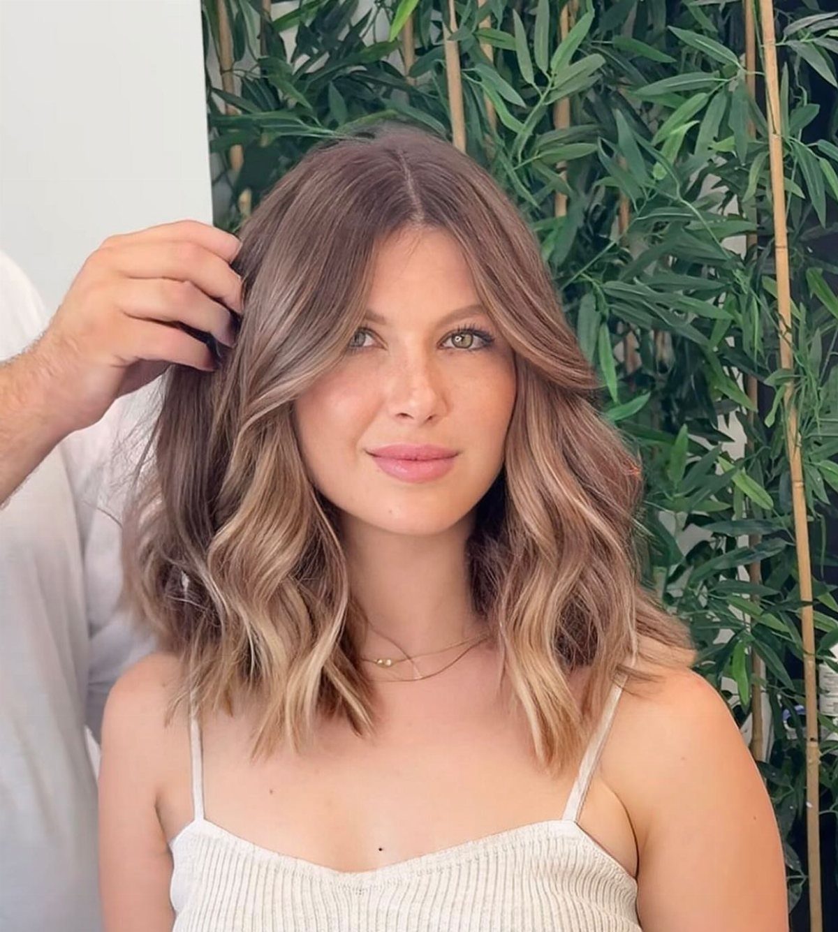 Woman showing wavy brown hair transitioning to blonde ends