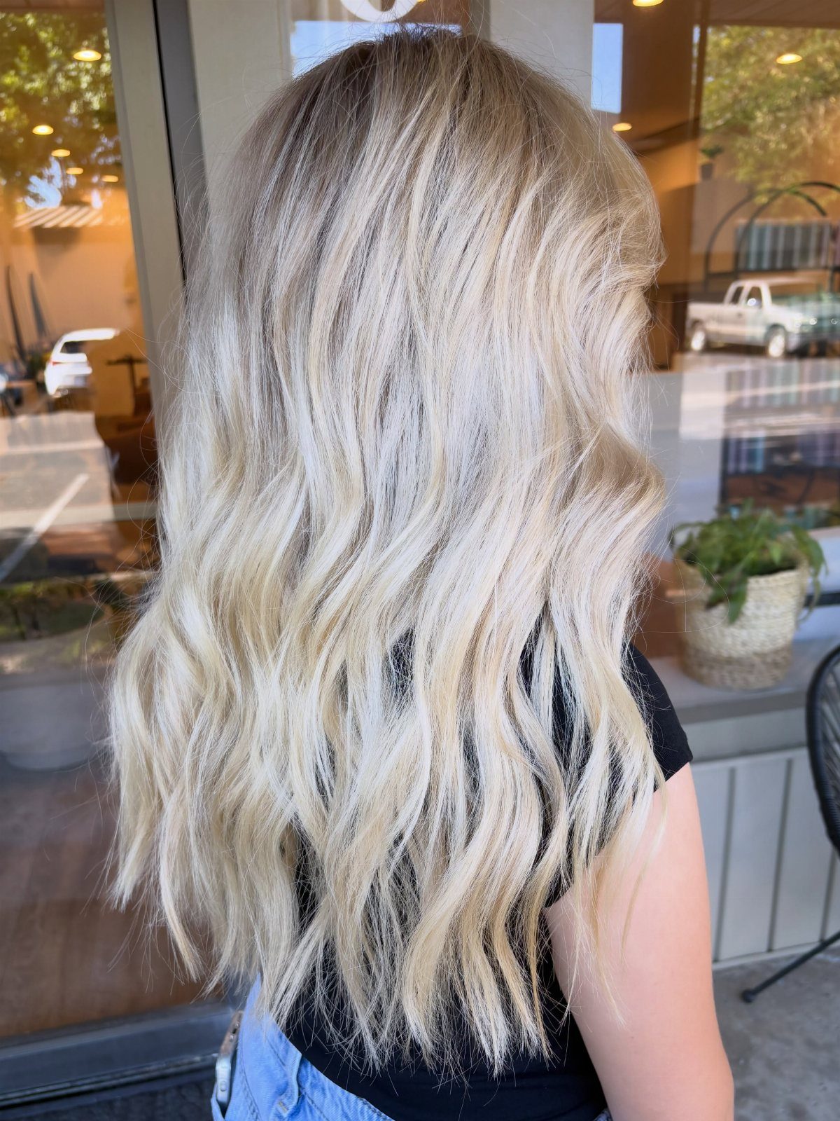 Long wavy hair with heavy pale blonde highlights over brown roots