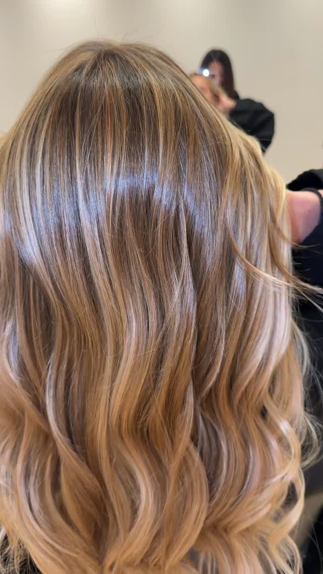 Wavy brown hair with fine honey-blonde highlights in a salon