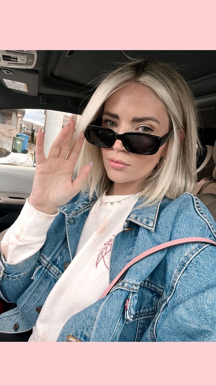 Woman with bright blonde face-framing sections and darker hair sitting in a car