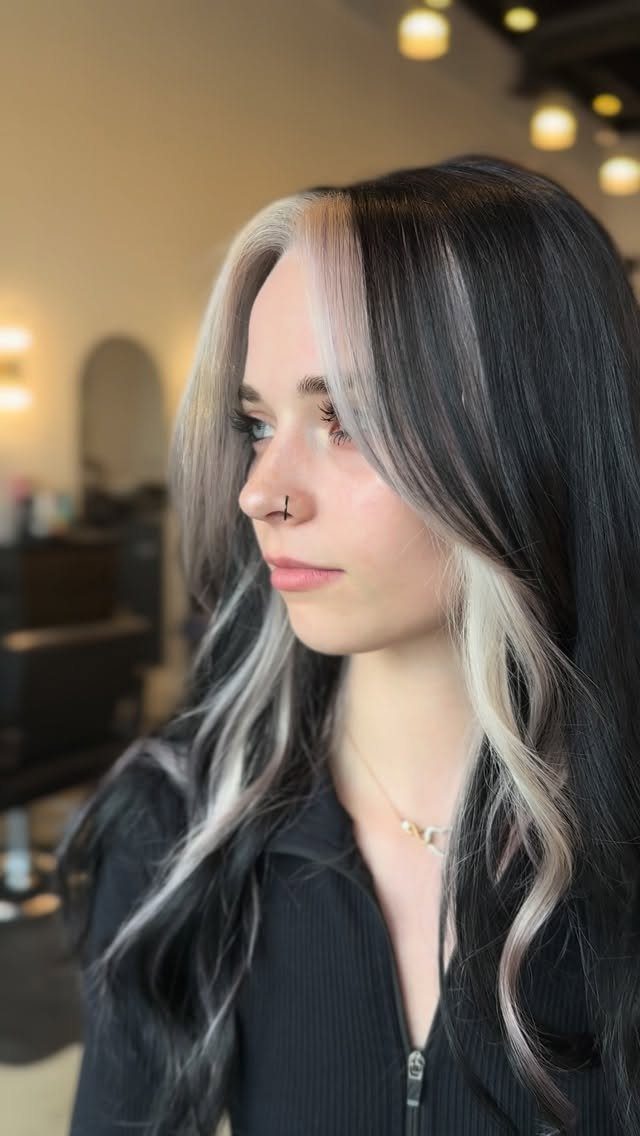 Woman with long brown hair and striking pale blonde face-framing sections