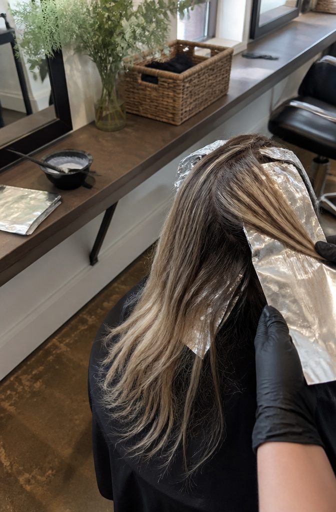 Hair showing smudged roots fine highlights bright ends and face framing pieces