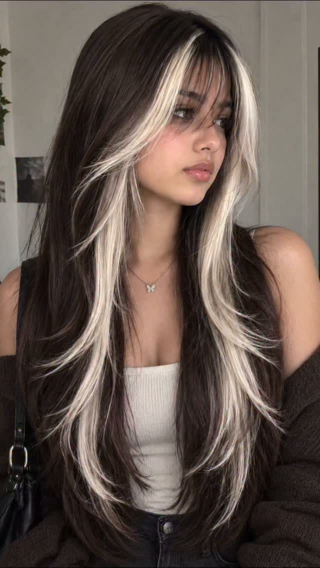 Woman with long brown hair and bold blonde face-framing highlights
