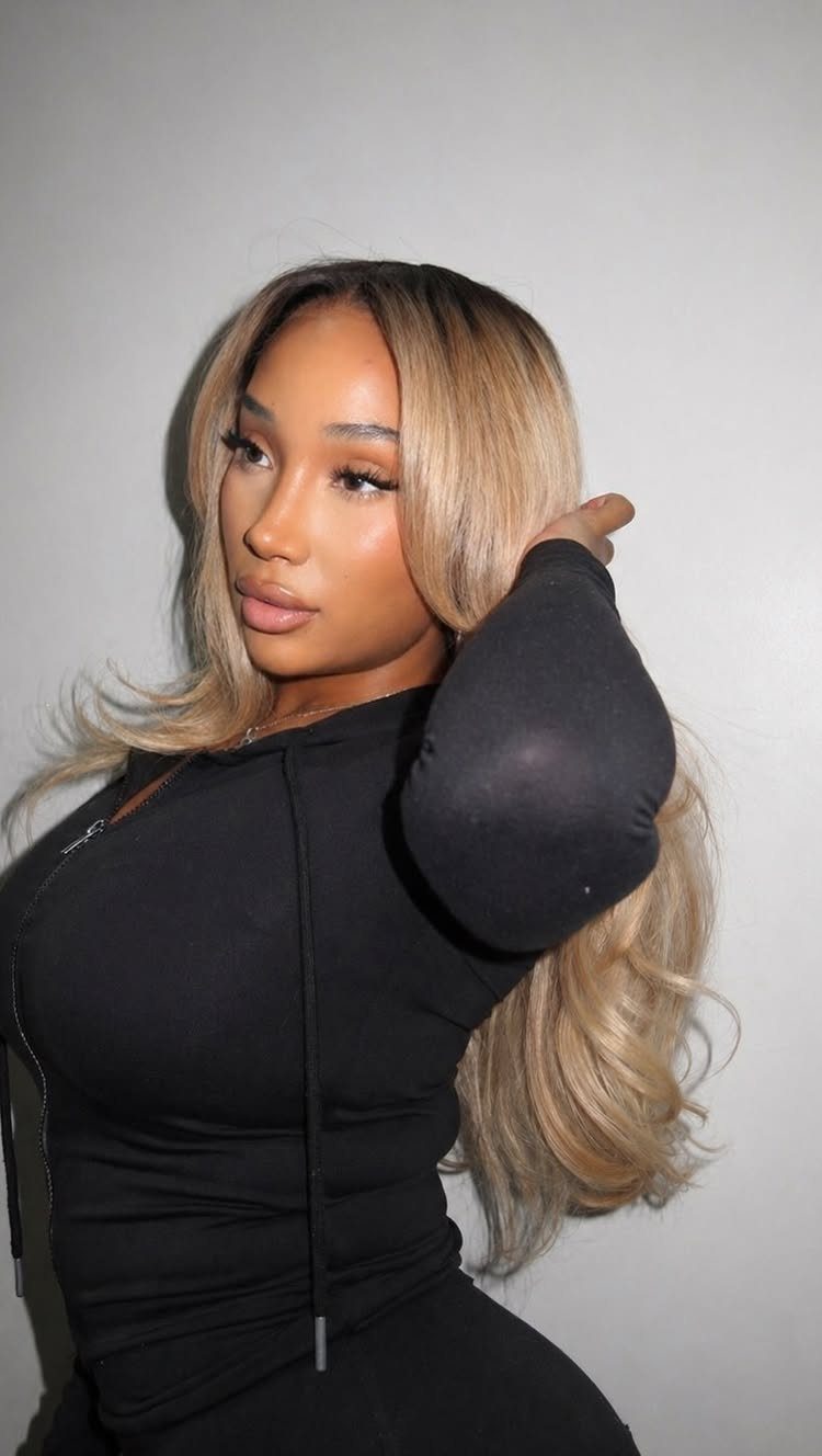 Long dark-rooted hair fades into pale ash blonde lengths and ends