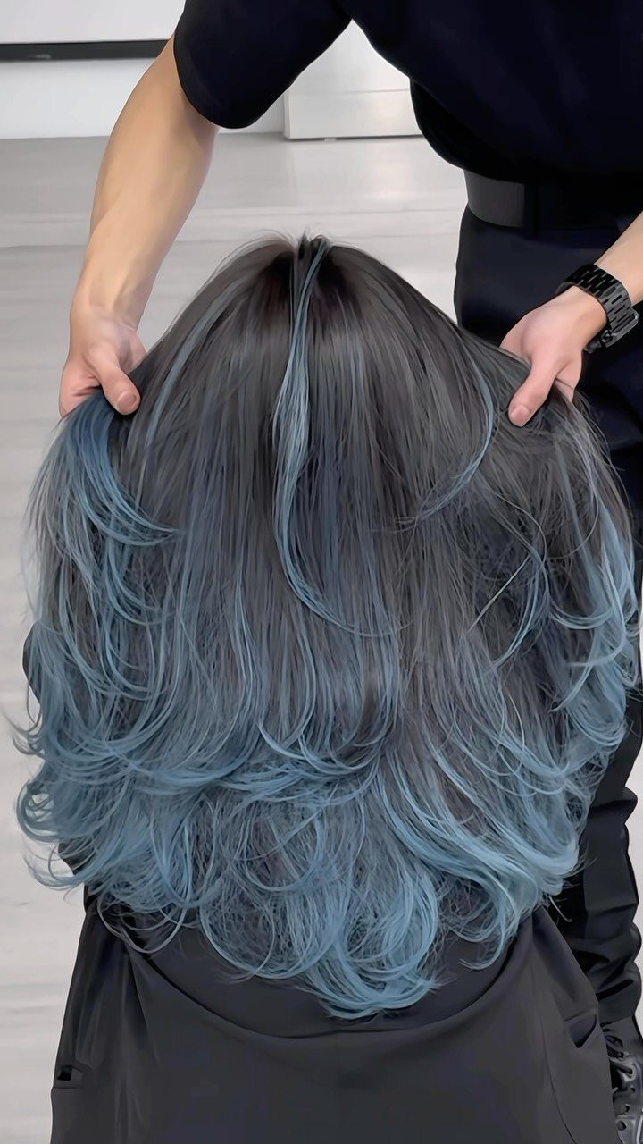 Blue ombre hair fades from dark gray roots into layered blue-gray ends