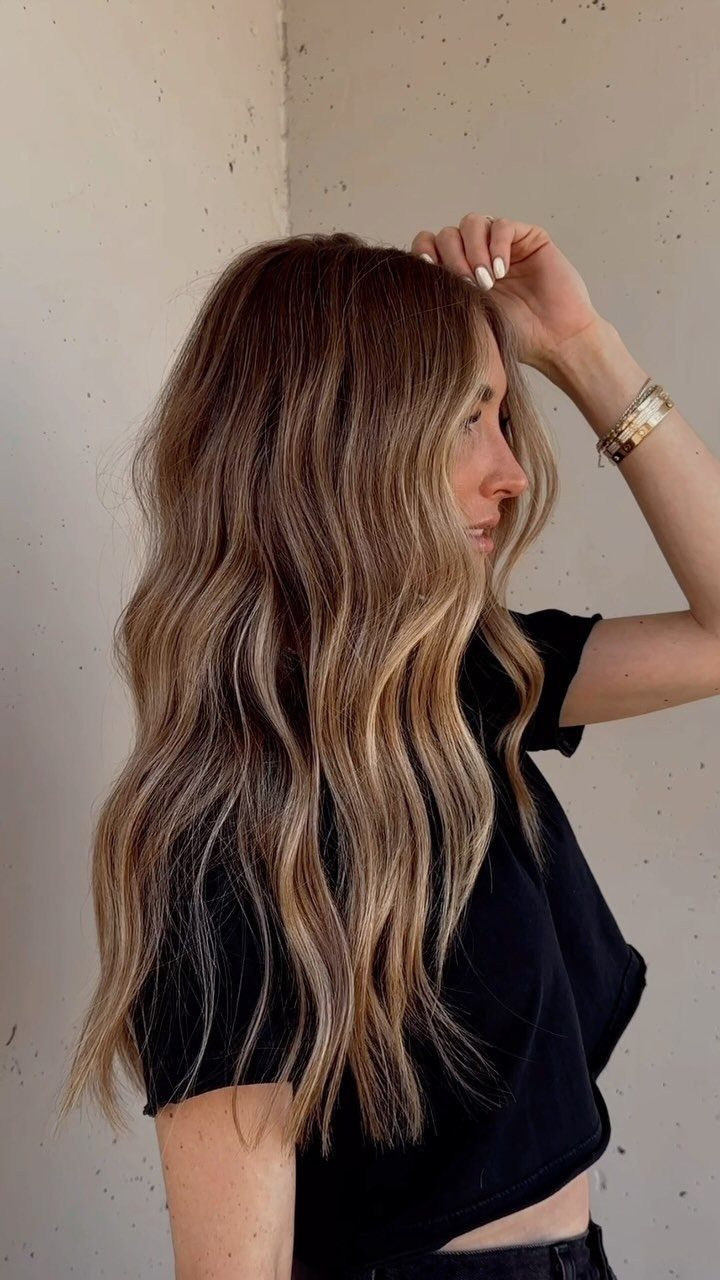 Long wavy bronde hair with dark roots and golden highlights