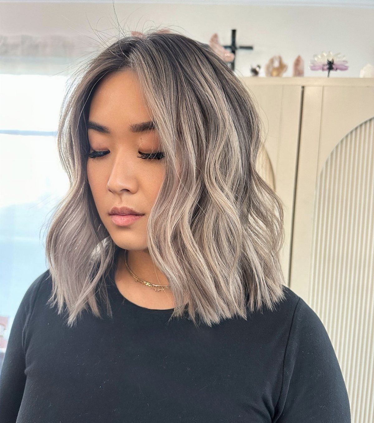 Wavy short bob with dark roots fading into cool blonde ends