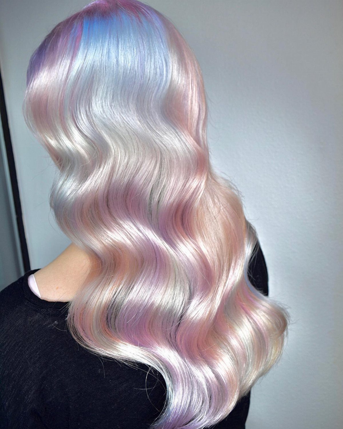 Long blonde waves with pastel blue, lavender, and pink streaks